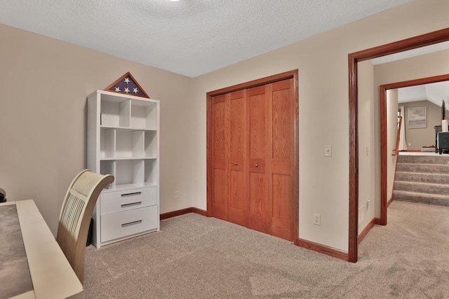 home office with light colored carpet and a textured ceiling