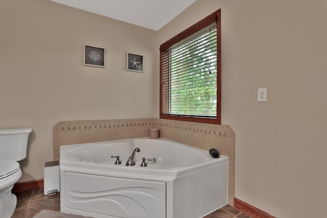 bathroom featuring tile patterned floors, a tub, and toilet