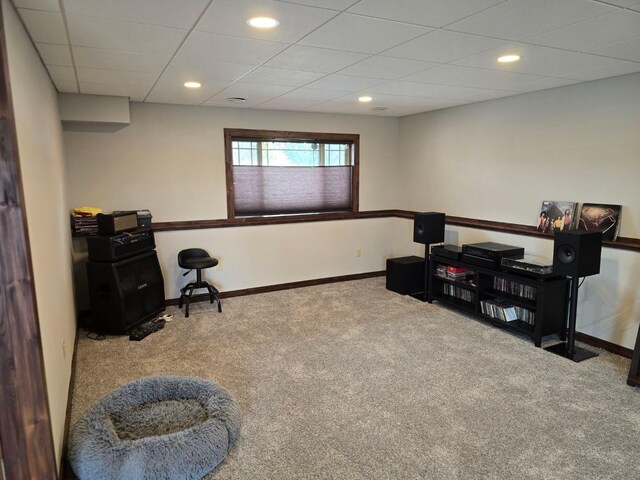 interior space featuring a paneled ceiling and carpet floors