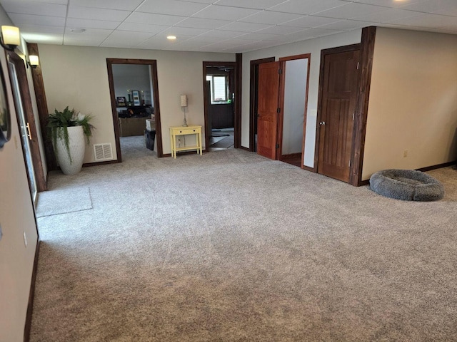 carpeted empty room with a paneled ceiling