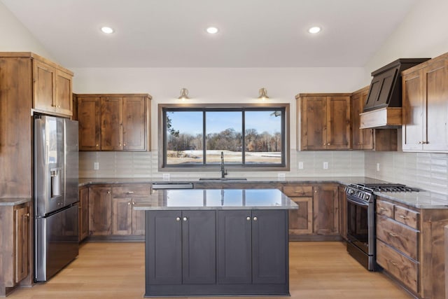 21933 Edison Ct, East Bethel, MN 55011 - kitchen with lofted ceiling, appliances with stainless steel finishes, sink, and a kitchen island