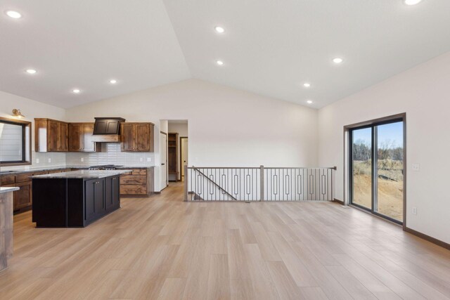 21933 Edison Ct, East Bethel, MN 55011 - kitchen with tasteful backsplash, lofted ceiling, a center island, and light wood-type flooring