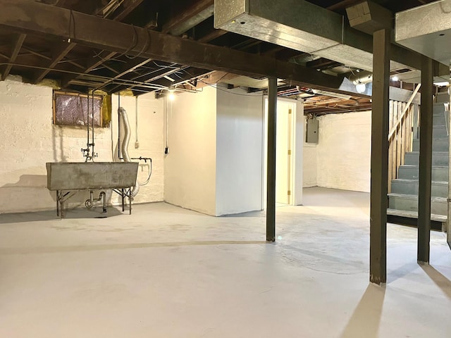 basement featuring electric panel and sink