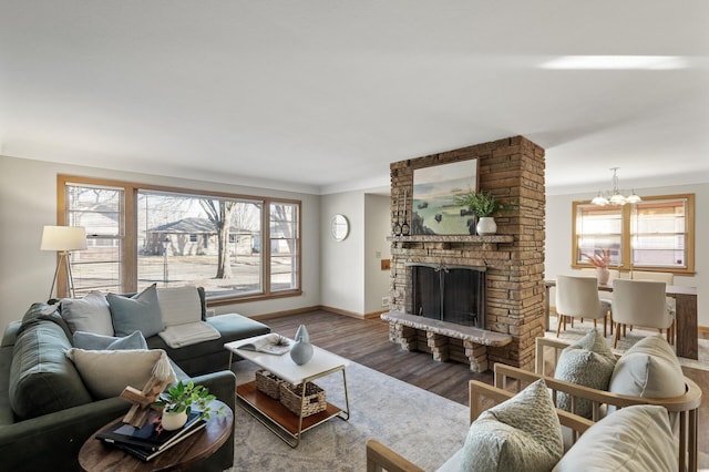 living room featuring a fireplace, wood-type flooring, and a chandelier