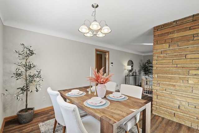 dining space featuring dark wood-type flooring and an inviting chandelier