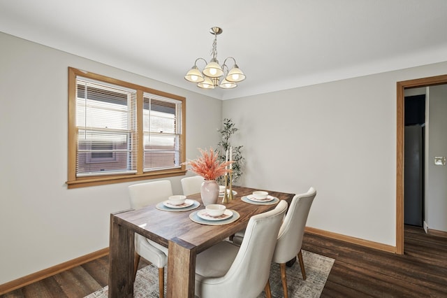 dining space with dark wood-type flooring and a notable chandelier