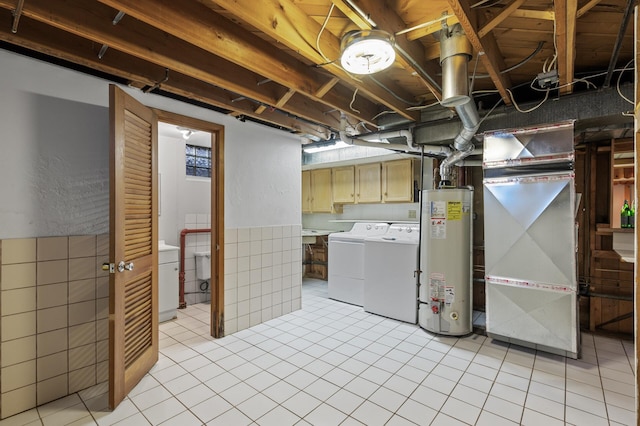 basement with gas water heater, separate washer and dryer, heating unit, and light tile patterned flooring