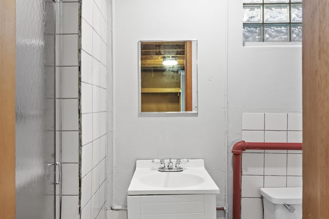 bathroom with walk in shower, vanity, and toilet