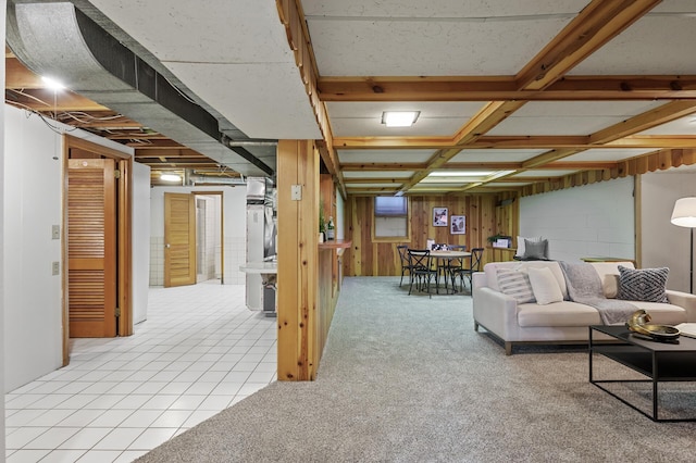 carpeted living room featuring wooden walls