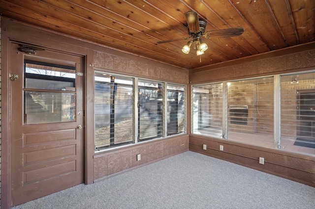 unfurnished sunroom with ceiling fan, a healthy amount of sunlight, and wooden ceiling