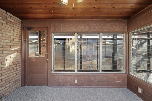 unfurnished sunroom with ceiling fan, wooden ceiling, and a healthy amount of sunlight