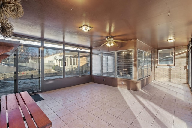 unfurnished sunroom featuring ceiling fan