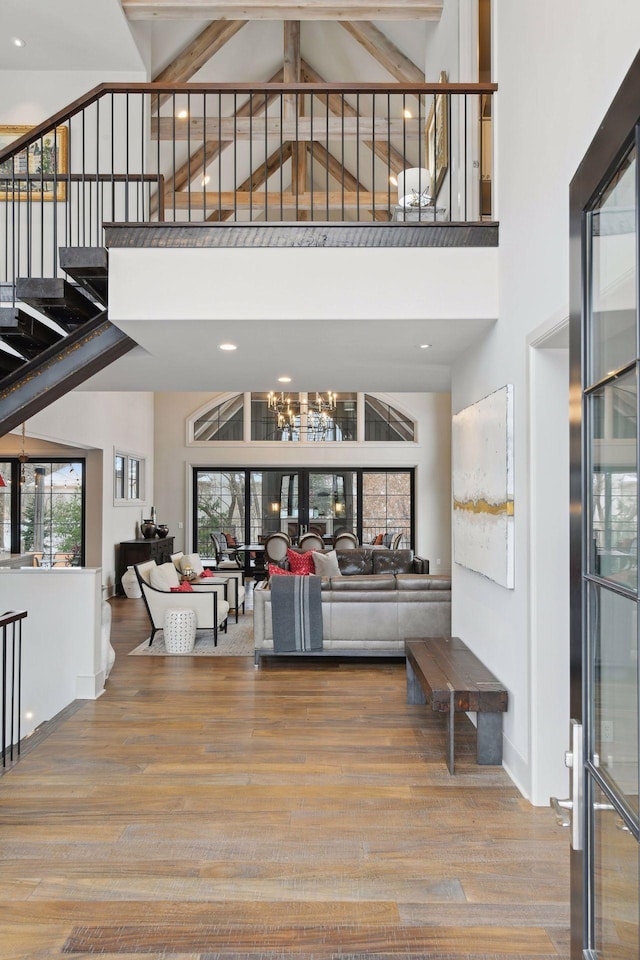 foyer entrance featuring light hardwood / wood-style flooring, a chandelier, and a high ceiling