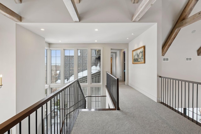 hall featuring beamed ceiling and carpet