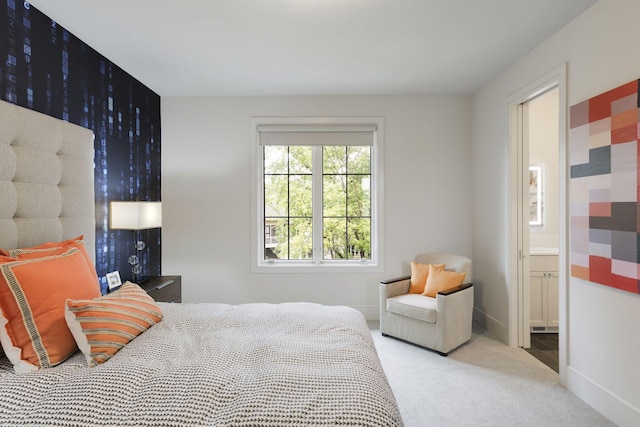 bedroom with ensuite bath and carpet floors