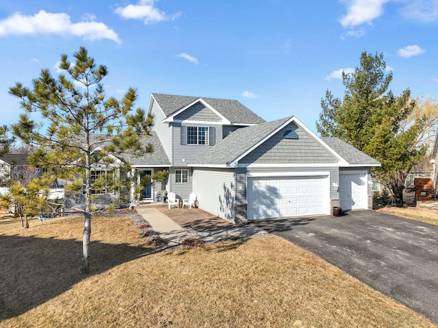 view of front facade featuring a garage, a front lawn, driveway, and a shingled roof