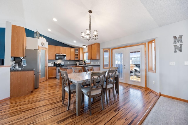 dining area with lofted ceiling, recessed lighting, french doors, light wood-style flooring, and a notable chandelier
