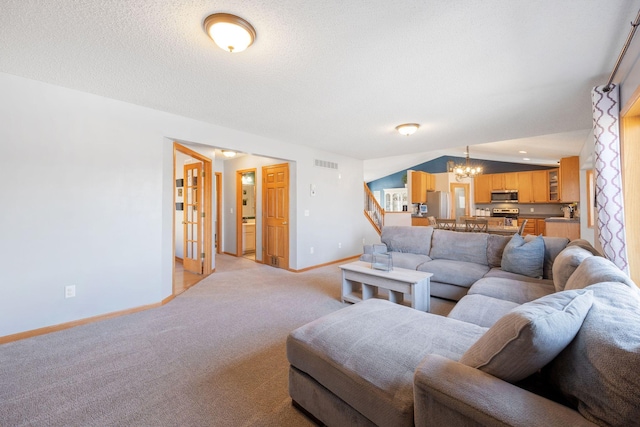 living area featuring visible vents, light colored carpet, baseboards, a chandelier, and stairs