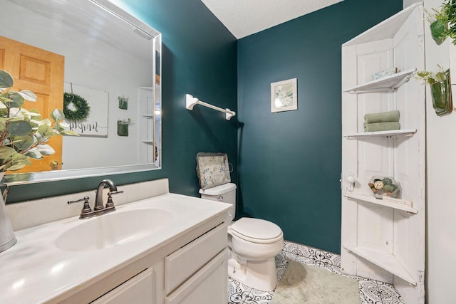 bathroom featuring toilet, tile patterned flooring, and vanity