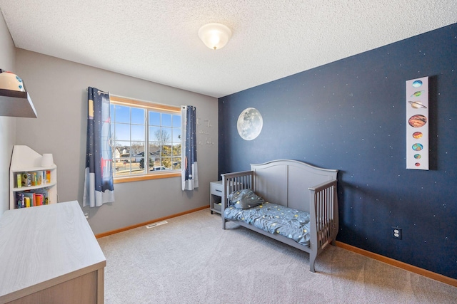 carpeted bedroom with baseboards, a textured ceiling, and visible vents