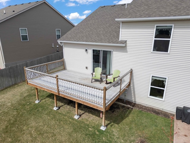18943 Ivanhoe St NW, Elk River, MN 55330 - back of house with fence, a lawn, a shingled roof, and a deck