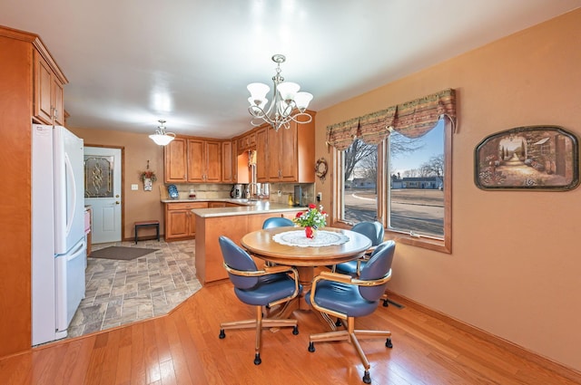 dining space with an inviting chandelier and light wood-type flooring