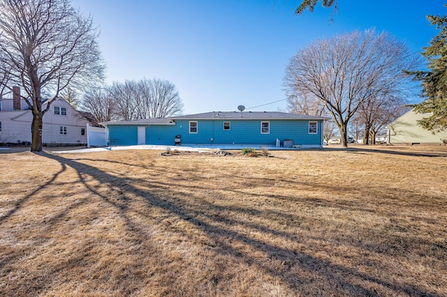 rear view of property featuring a yard