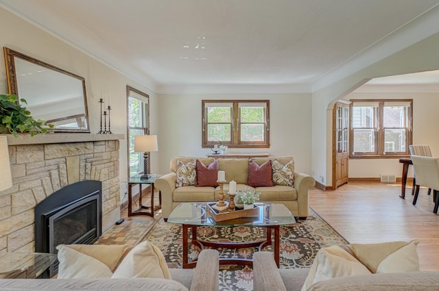 5524 Columbus Ave, Minneapolis, MN 55417 - living area with light wood-style flooring, ornamental molding, arched walkways, and a stone fireplace