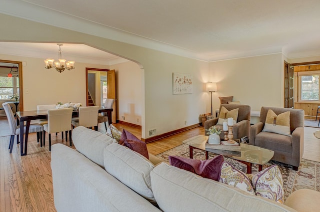 5524 Columbus Ave, Minneapolis, MN 55417 - living room featuring light wood-style flooring, a chandelier, arched walkways, crown molding, and stairway