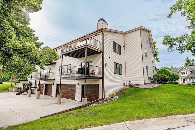 exterior space with an attached garage, a balcony, driveway, a lawn, and a chimney