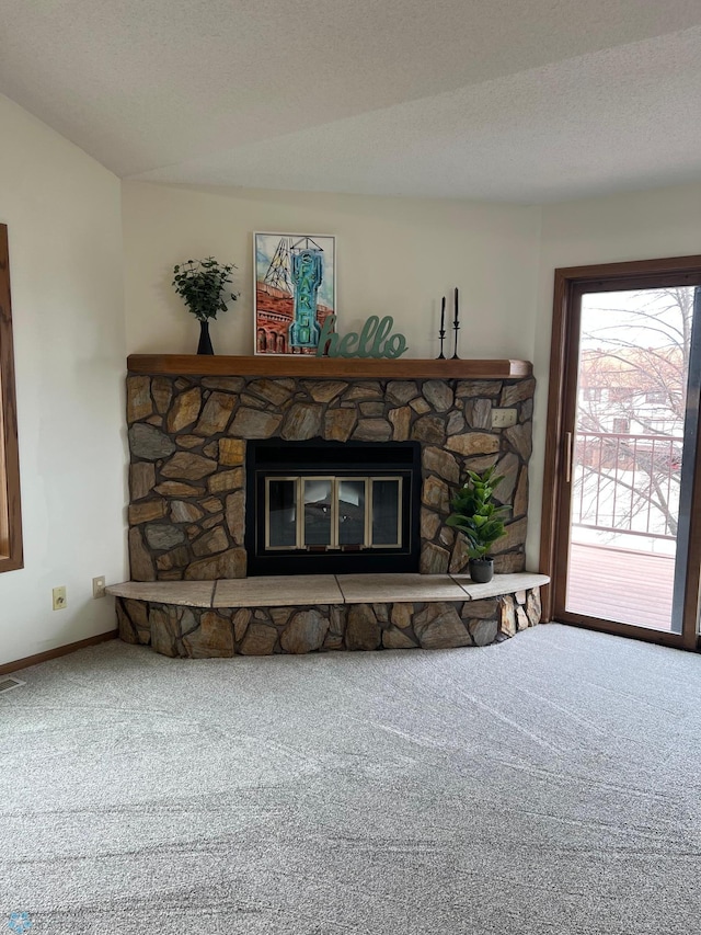 carpeted living area featuring a textured ceiling and a stone fireplace