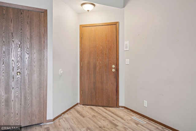 entrance foyer featuring a textured ceiling and light hardwood / wood-style flooring