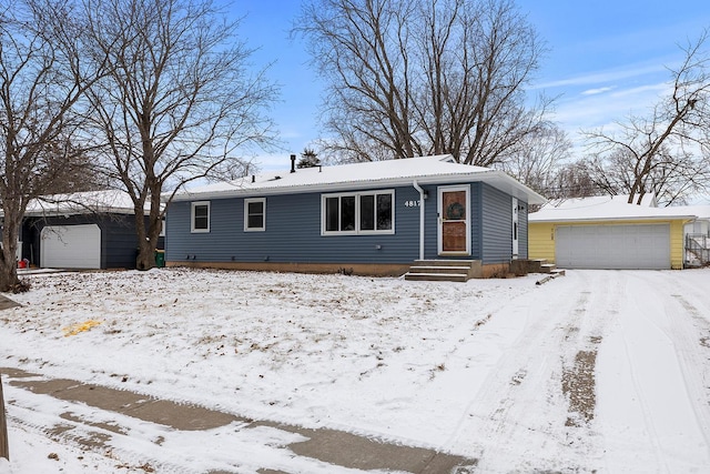 view of front of home with a garage and an outbuilding