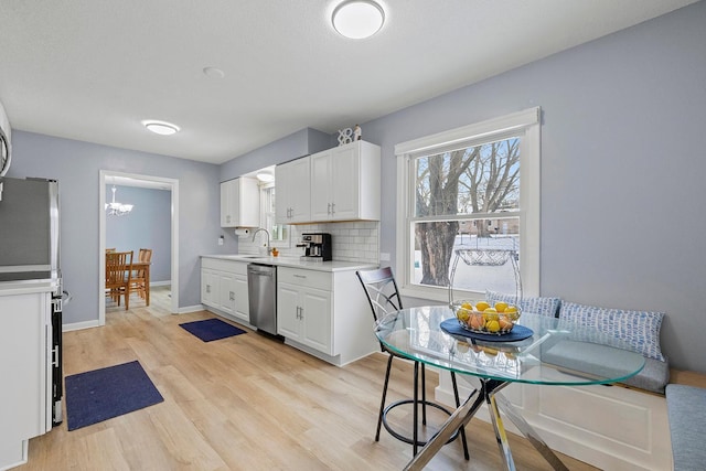 kitchen featuring stainless steel dishwasher, sink, decorative backsplash, and white cabinets