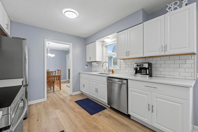 kitchen with tasteful backsplash, stainless steel appliances, white cabinets, and light wood-type flooring