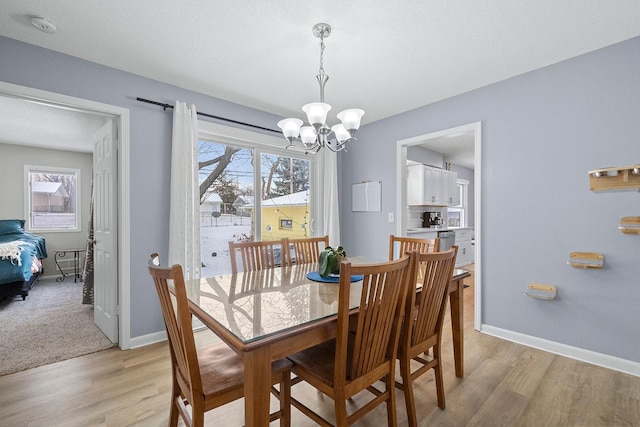 dining room with a notable chandelier and light wood-type flooring