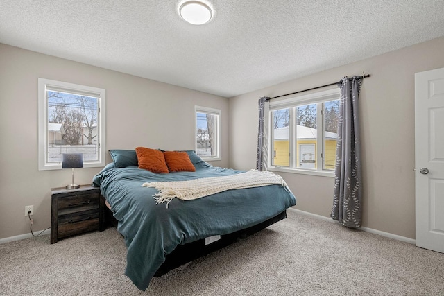 bedroom featuring light colored carpet and a textured ceiling