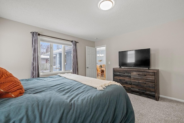 bedroom with carpet, a chandelier, and a textured ceiling