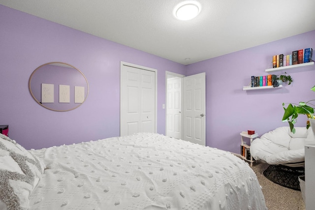 bedroom featuring carpet, a closet, and a textured ceiling