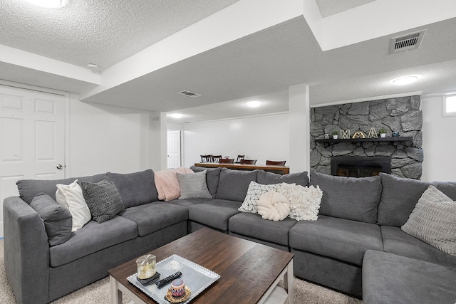 living room featuring a stone fireplace and a textured ceiling