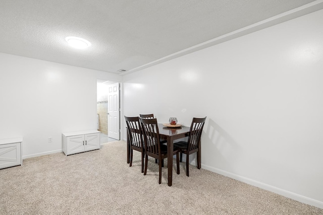 carpeted dining room with a textured ceiling