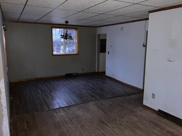 unfurnished room with crown molding, dark wood-type flooring, and a paneled ceiling