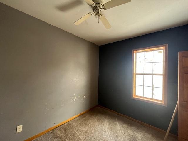 empty room with carpet flooring, baseboards, and a ceiling fan