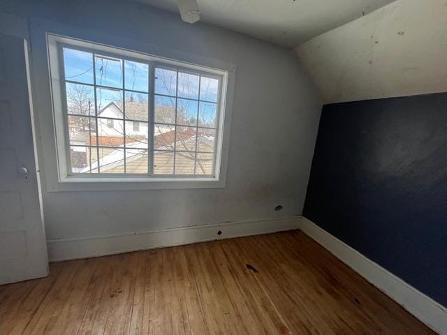 bonus room with lofted ceiling, baseboards, and wood finished floors