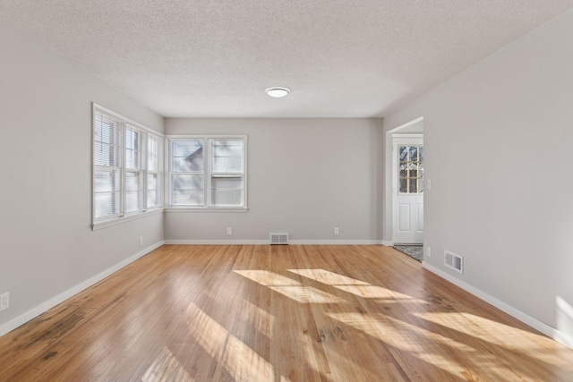 spare room with hardwood / wood-style flooring and a textured ceiling