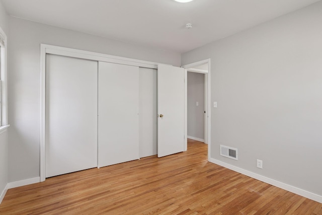 unfurnished bedroom featuring a closet and light hardwood / wood-style flooring