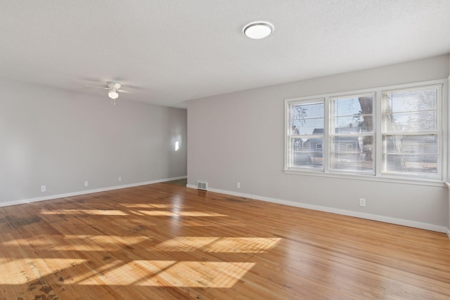 unfurnished room with ceiling fan, light hardwood / wood-style flooring, and a textured ceiling