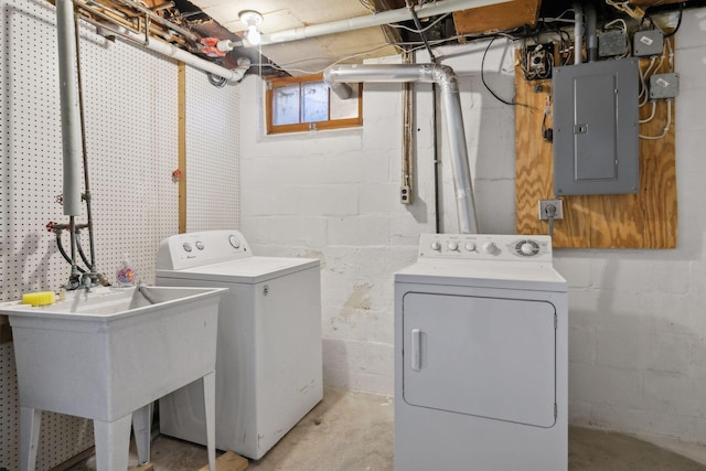 clothes washing area with sink, electric panel, and washer and clothes dryer