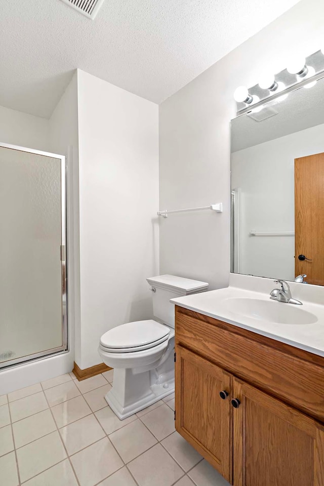 bathroom with vanity, toilet, tile patterned floors, a textured ceiling, and a stall shower