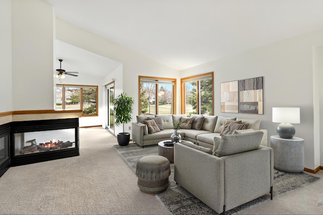 living area featuring carpet flooring, a ceiling fan, vaulted ceiling, and plenty of natural light